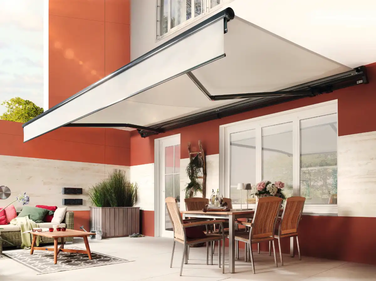 Moderne Gelenkarm-Markise mit Esstisch und Pflanzen